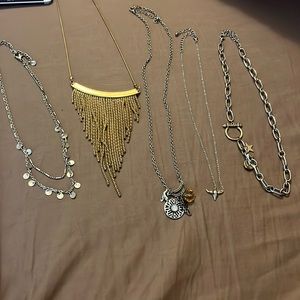 One gold and four silver necklaces all with accented beads